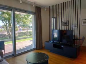 a living room with a tv and a large sliding glass door at Villa Szyprów in Jastarnia