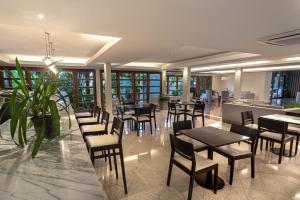 a restaurant with tables and chairs in a room at Hotel Saint George in Puerto Iguazú