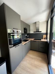 a kitchen with white cabinets and a large window at Appartement T3 Pra Loup 1600 in Pra-Loup