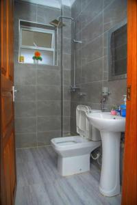 a bathroom with a toilet and a sink at Kezmo Paradise in Mombasa