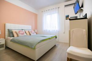 スプリトにあるApartment David, 2mins from town centreのピンクの壁のベッドルーム1室(窓付)