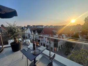 a balcony with a table and chairs and the sunset at StadtBlick Hotel in Bad Salzuflen +3 photos