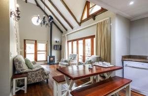 a living room with a wooden table and chairs at Hogsback Arminel Self catering Cottages in Hogsback
