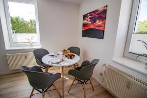 a dining room with a white table and chairs at Harzträume No3 & No4 # Parkplatz # separate SZ # Smart-TV in Wernigerode