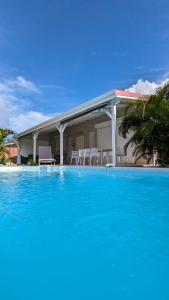 a large blue swimming pool in front of a house at Villa MIA in Saint-François