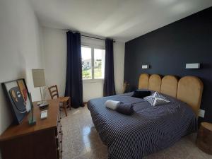 a bedroom with a bed and a desk and a window at Villa au calme, tout confort clim piscine wifi 7 personnes in Caunes-Minervois +32 photos
