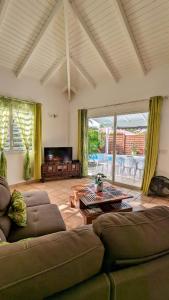 a living room with two couches and a table at Villa MIA in Saint-François +13 photos