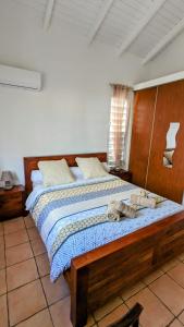 a bedroom with a wooden bed with towels on it at Villa MIA in Saint-François