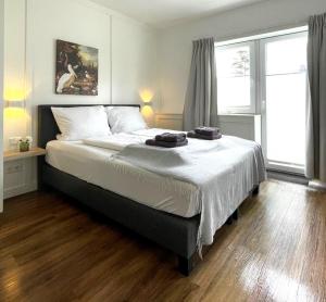 a bedroom with a large bed with white sheets at Die zwei Löwen Ferienwohnungen in Winterberg