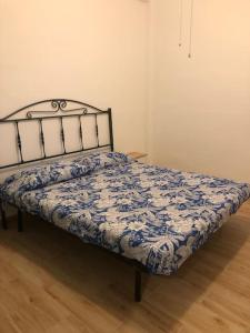 a bedroom with a bed with a blue and white comforter at La vecchia quercia in Carini