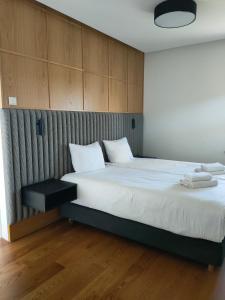 a bedroom with a large bed with white sheets at Villa Szyprów in Jastarnia