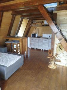 a attic room with a bed and a kitchen at Kucica za odmor in Belanovica