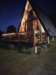a cabin at night with a fence and lights at Kucica za odmor in Belanovica