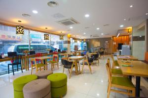 a restaurant with tables and chairs and a cafeteria at Jeju R Hotel & Guesthouse in Jeju