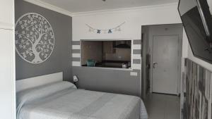 a small bedroom with a bed and a kitchen at Estudio TORROX PLAYA- vistas al mar y piscina in Torrox Costa