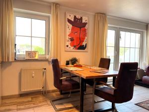 una sala da pranzo con tavolo e sedie di fewo1846 - Wellenrauschen - strandnahes Apartment mit Balkon und Meerblick a Harrislee