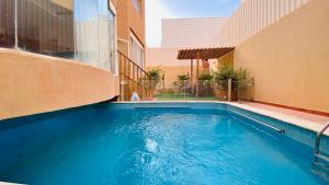 a large blue swimming pool next to a building at Elegant Apartment - Private Pool & Garden Views in Riyadh