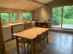 a large kitchen with a wooden table and chairs at Chambre d'hôte in Monflanquin