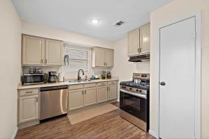 a kitchen with white cabinets and stainless steel appliances at Cozy and Stylish 3-Bedroom Sanctuary in Seabrook