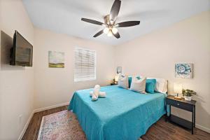 a bedroom with a blue bed with a ceiling fan at Cozy and Stylish 3-Bedroom Sanctuary in Seabrook