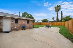 a backyard with a brick house and a fence at Cozy and Stylish 3-Bedroom Sanctuary in Seabrook