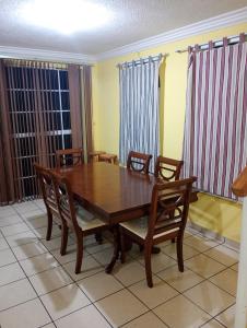Un comedor con mesa y sillas de madera. en Santa Ana tu mejor opción, en Santa Ana