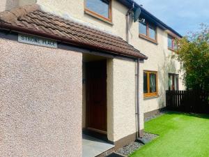 a house with a brown door and a green yard at Fairview House in Caol