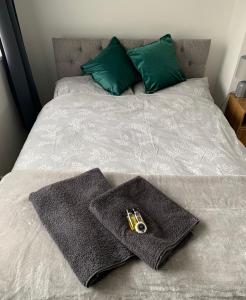 a bed with two towels and a camera on it at Modernised home with 2 bedrooms in Cardiff in Cardiff +3 photos