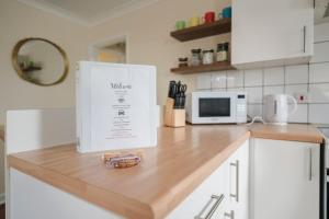 a white appliance sitting on top of a kitchen counter at Ely Stays Flat 1 Stylish City Centre Apartment in Ely