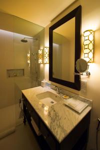 a bathroom with a mirror and a sink at Galle Face Hotel in Colombo