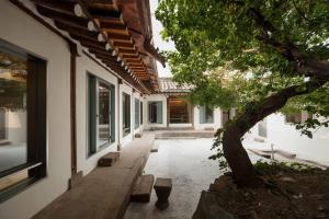 a courtyard of a house with a tree next to it at Side Hanok Residence in Seoul