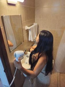 Una mujer secándose el pelo en un baño. en Habitacion tipo hotel centrico 3 camas, cocina,WIFI E, en Ciudad Valles 49 fotos más