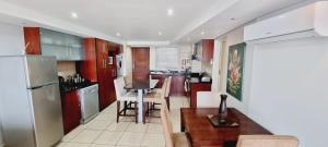 a kitchen with a table and a kitchen with a refrigerator at Nautica 406 in Mossel Bay