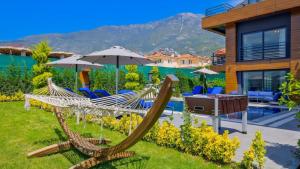 a hammock in the yard of a house at Luxury Villa Close to Shops and Restaurants -Large Garden Pool Table and Table Tennis in Fethiye