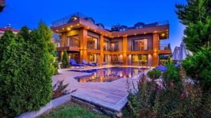a large house with a swimming pool in front of it at Luxury Villa Close to Shops and Restaurants -Large Garden Pool Table and Table Tennis in Fethiye
