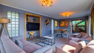 a living room with couches and a tv and a table at Luxury Villa Close to Shops and Restaurants -Large Garden Pool Table and Table Tennis in Fethiye