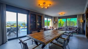 a living room with a wooden table and chairs at Luxury Villa Close to Shops and Restaurants -Large Garden Pool Table and Table Tennis in Fethiye