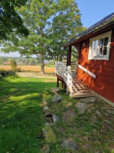 a bench sitting on the porch of a house at Rolsmo Norregård 16 in Linneryd +17 photos