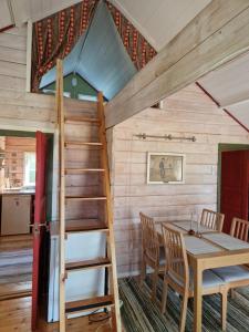a room with a table and chairs and a ladder at Rolsmo Norregård 16 in Linneryd