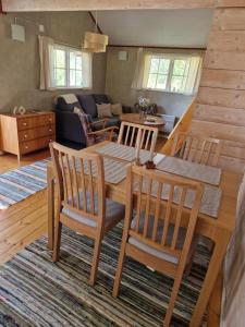 a dining room and living room with a table and chairs at Rolsmo Norregård 16 in Linneryd