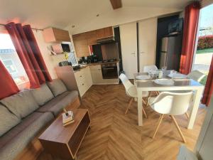 a living room with a couch and a table at Les flots de Condrieu - VIA -RHÔNA -8 pers, et vue sur Rhône-BBQ in Condrieu