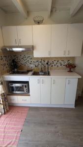 a kitchen with white cabinets and a microwave at Gîte Richmond Inn in Richmond
