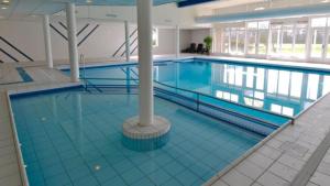 een groot zwembad in een groot gebouw bij 't Klèène Genot in Hollum
