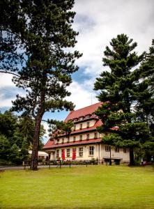 een groot gebouw met twee bomen ervoor bij Parkhotel Skalní město in Jičín