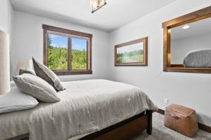 a bedroom with a bed and a mirror at Snowghost Den True Ski In Ski Out Home Sleeps 9 with 3 Bedrooms 2 and a half Bathrooms and Private Hot Tub in Whitefish