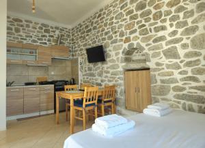 a kitchen with a table and a stone wall at Rigas stone tower east Mani 2 in Agriliá +10 photos