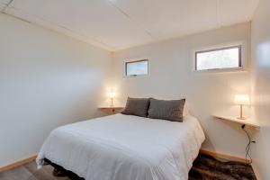 a bedroom with a white bed and two windows at Pet-Friendly Cabin with Grill in Hillsgrove in Hillsgrove