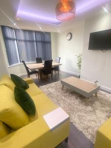 a living room with a yellow couch and a table at Lovely 4 bedroom, 2 bathroom house near city centre in Roundhay
