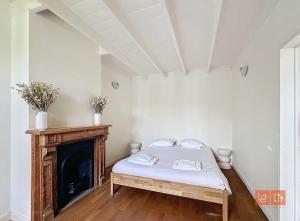 Un dormitorio con una cama y una chimenea. en Cap Blanc-Nez - 6 personnes - animaux acceptés, en Escalles
