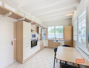 Una cocina con gabinetes blancos y una mesa y sillas. en Cap Blanc-Nez - 6 personnes - animaux acceptés, en Escalles